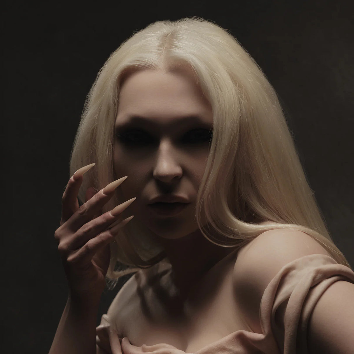 Woman with blonde hair and dark makeup against a black background