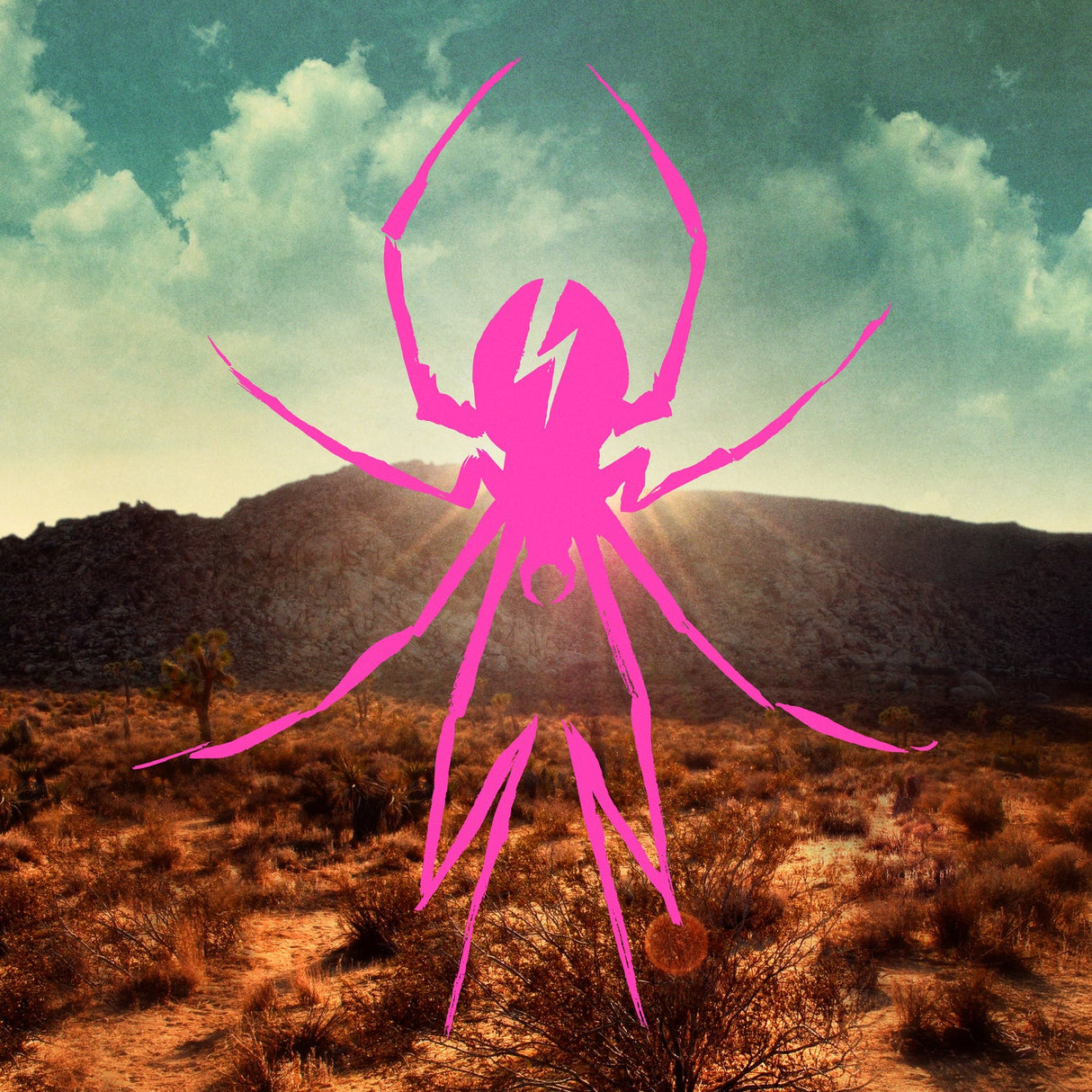 Pink spider silhouette over a desert landscape with mountains and clouds.