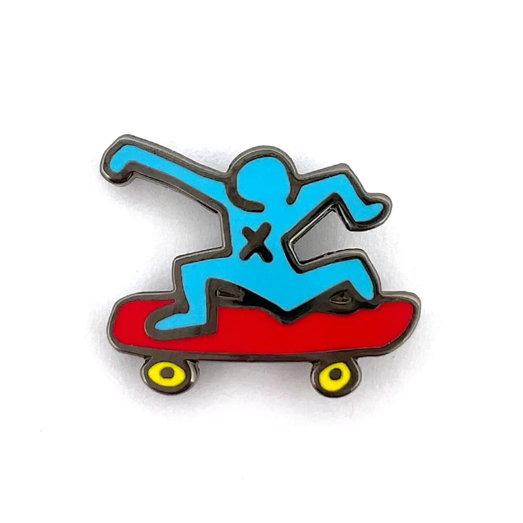 A pin shaped like a stylized figure on a skateboard with a blue and red color scheme, representing the artwork of Keith Haring.