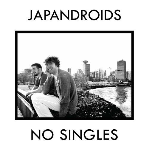 A vinyl record titled 'Japandroids - No Singles' with an image of two smiling men sitting close by a body of water, with a cityscape in the background.
