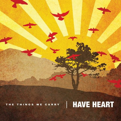 Artistic depiction of a tree with red birds against a yellow sunburst background, featuring text 'The Things We Carry Have Heart'.