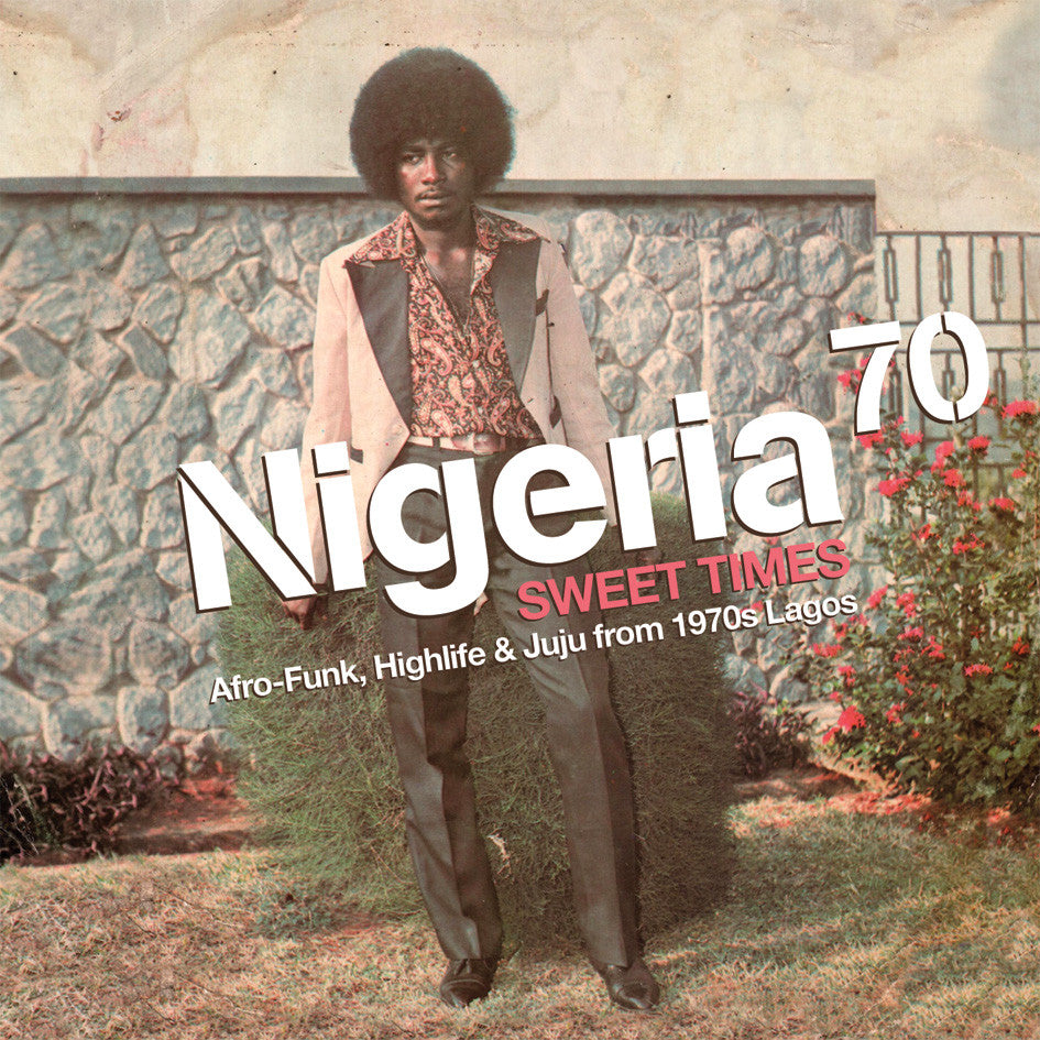The image shows the cover of the album 'Nigeria 70: Sweet Times' featuring a man in a suit with a funky hairstyle, standing against a wall with a flowering shrub in the foreground. The text on the cover indicates that it is a compilation album exploring music from Nigeria in the 1970s.