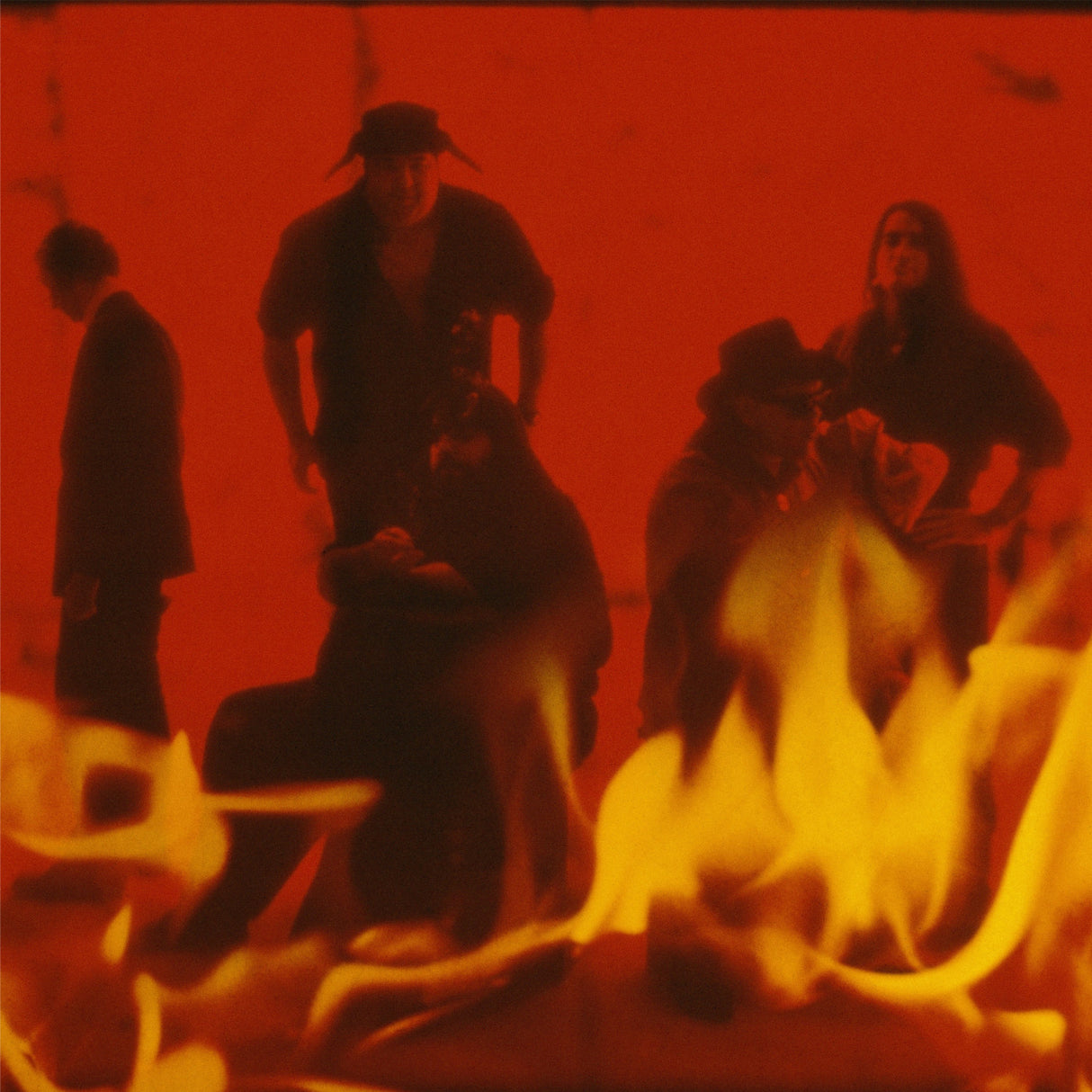 Group of people around a fire with a red filter