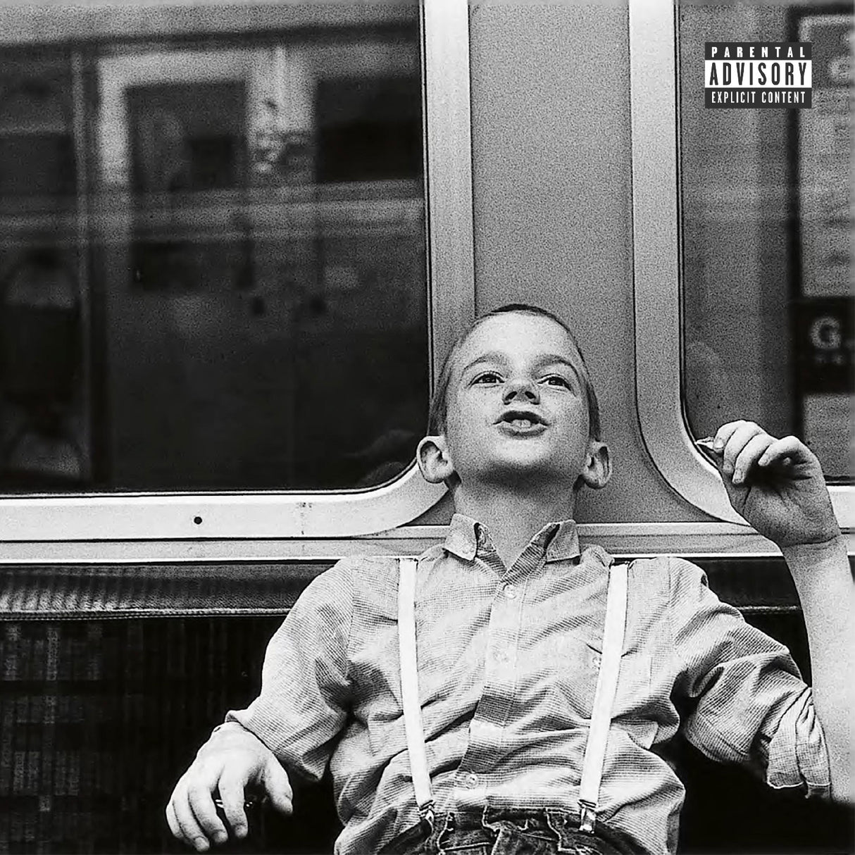 Black and white album cover with a child sitting on a bus, featuring a parental advisory label.