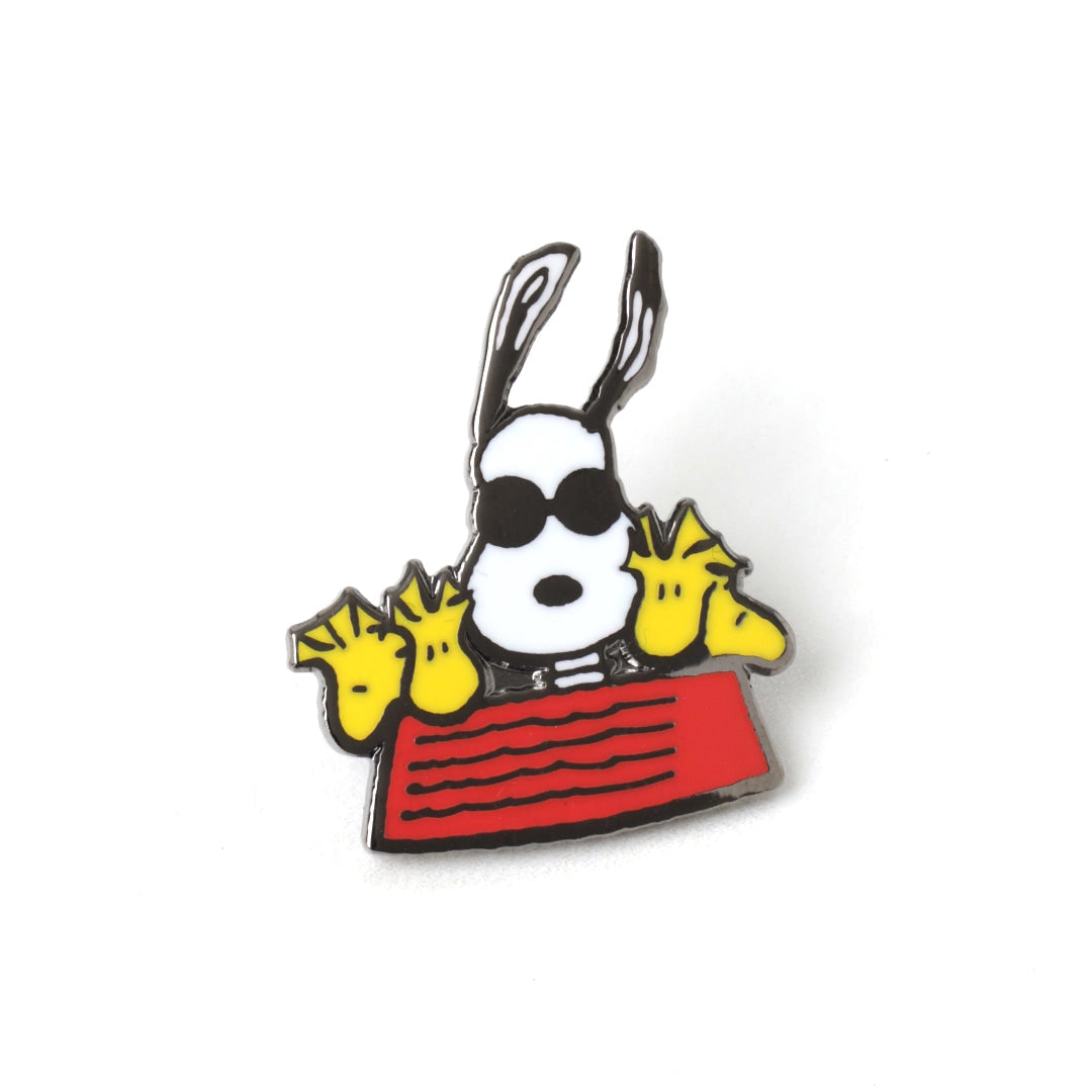 Pin with cartoon character holding a newspaper on a white background