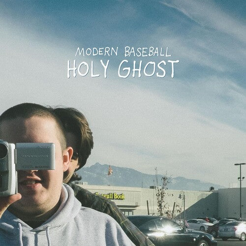 Album cover with 'Modern Baseball' and 'Holy Ghost' text, person holding a camera, and mountainous background.