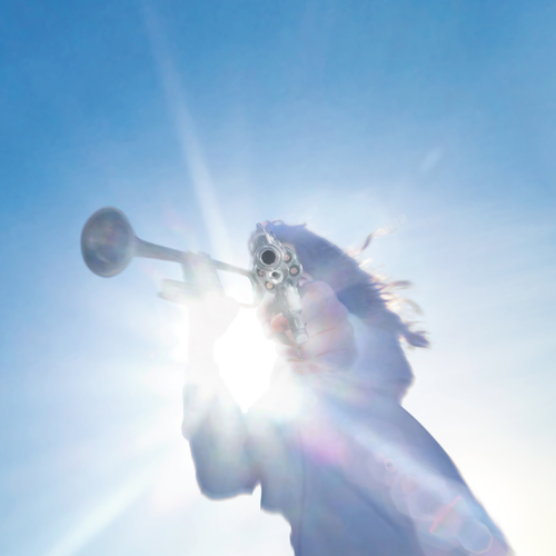 Person playing a trumpet against a bright blue sky with lens flare