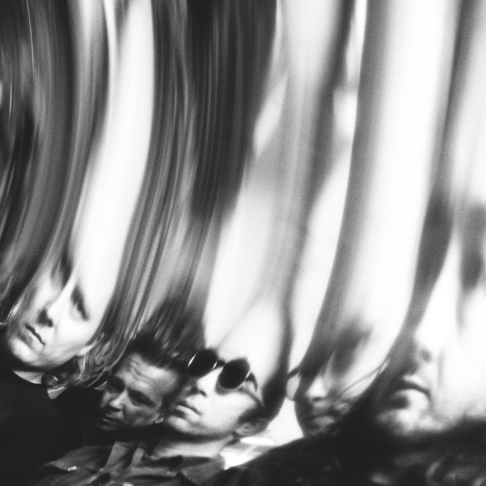 Black and white artistic photograph of multiple distorted, mirrored reflections of a man's face and profile, creating a high-contrast abstract composition.