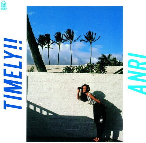 A vinyl record titled 'Anri - Timely!!' with a tropical-themed cover featuring palm trees and a woman leaning on a wall.
