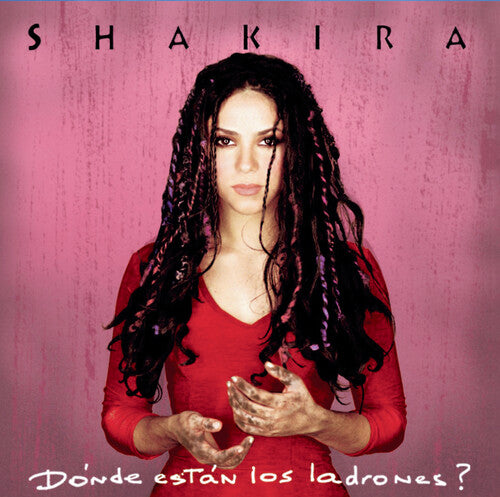 Shakira album cover for 'Donde Estan los Ladrones?' featuring the artist in a red dress against a pink background, holding a microphone.