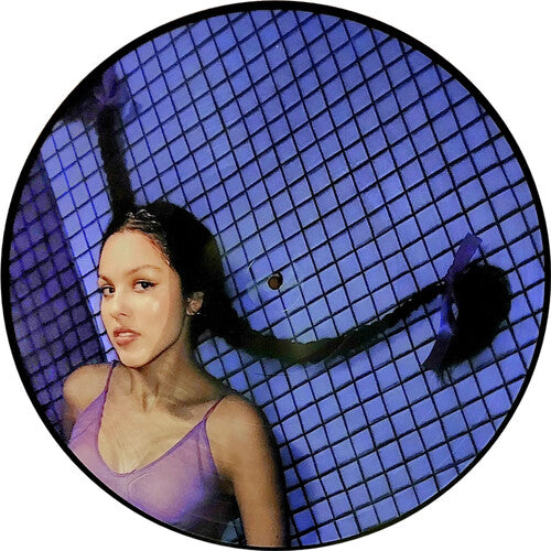 A picture disc of Olivia Rodrigo in a clear PVC sleeve, featuring an image of Olivia Rodrigo with a purple hue, against a blue grid-patterned background.