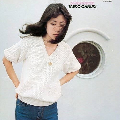 The image features the cover of the LP record titled "Sunshower" by Taeko Ohnuki. The cover depicts a woman with long, dark hair, standing near a window with a blurred view of a cityscape.