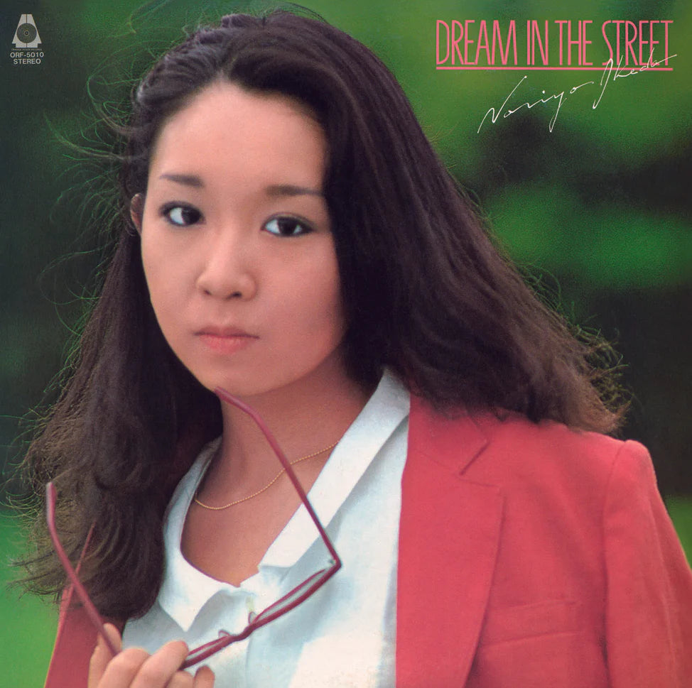 Album cover with a person wearing a red blazer against a green background, featuring text 'Dream in the Street'.