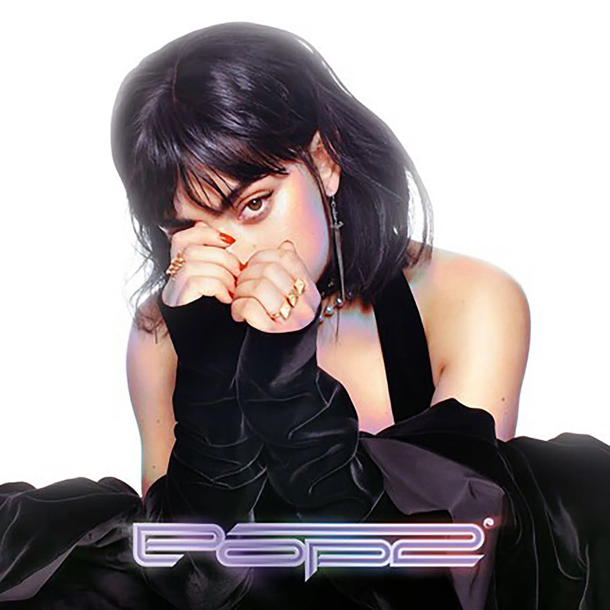 A stylized portrait of a woman with dark hair and bangs, wearing a black sleeveless dress and long black gloves, with rings on her fingers, against a white background. The word 'Pope' appears in a metallic stylized font at the bottom.