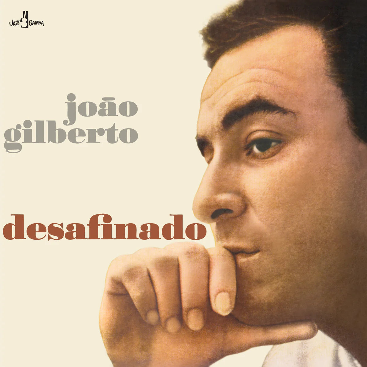 Album cover of 'Desafinado' by João Gilberto featuring a photo of the artist with a finger to his lips, suggesting a thoughtful or quiet gesture, with the title of the album below.