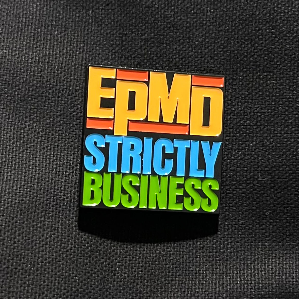 Colorful 'EPMD Strictly Business' badge on a black background