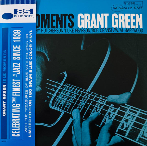 A vinyl record titled 'Moments' by Grant Green, featuring a black and blue cover with a guitar graphic and text indicating it's a Blue Note Records release.