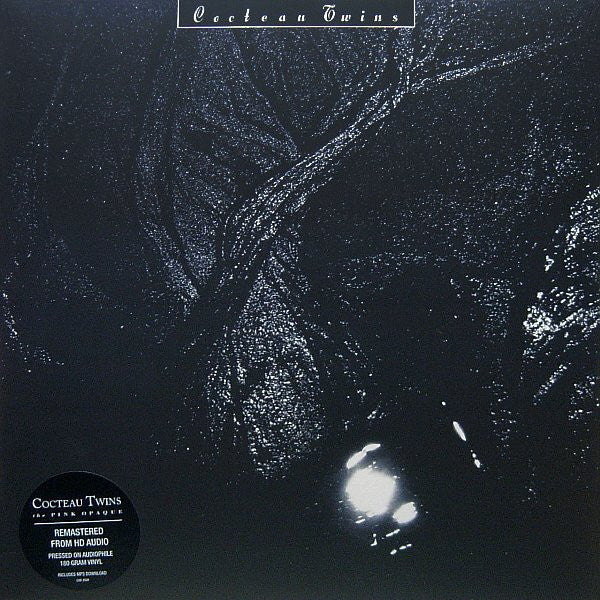 The image features the album cover of "The Pink Opaque LP" by Cocteau Twins. The artwork is moody and atmospheric, depicting a dark, textured landscape with scattered light points, possibly representing a night scene in an urban or industrial setting.
