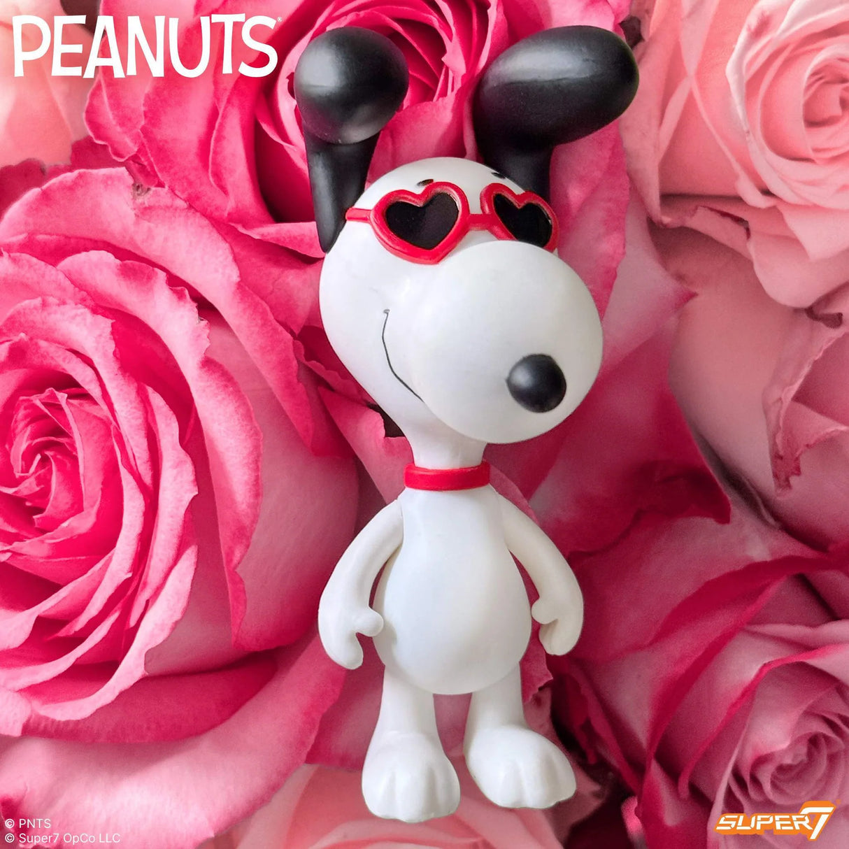 Snoopy figurine with heart-shaped sunglasses on pink roses