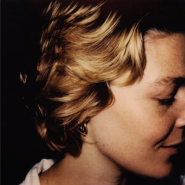 Close-up album cover of Maggie Rogers with a green vinyl record visible.