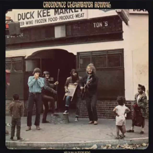 A vintage album cover featuring Creedence Clearwater Revival. The image depicts four members of the band standing in front of a store with a crowd of people around them, creating a lively and performative atmosphere.