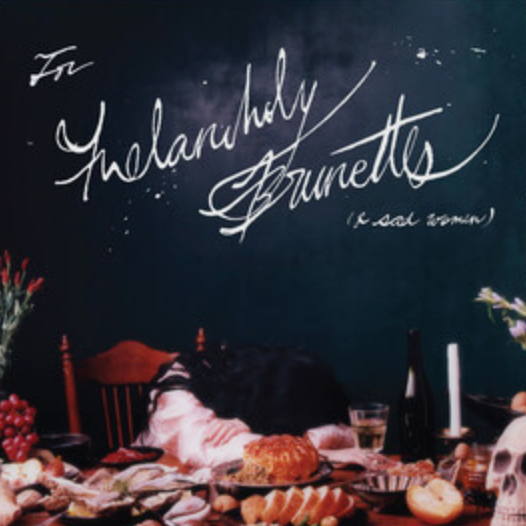 Album cover for Japanese Breakfast's 'For Melancholy Brunettes (& Sad Women)' featuring a frosted shadowed color with a cursive script and a backdrop of a table set with food and drinks.
