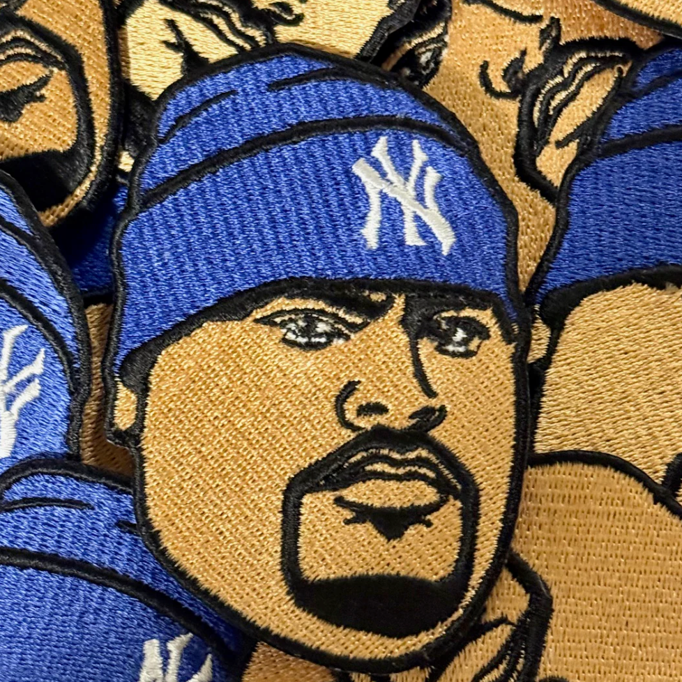 Patch of a person wearing a blue cap with a logo, surrounded by similar patches.