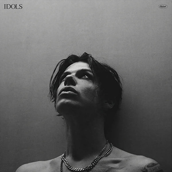 Black and white album cover with a person against a plain background, featuring the word 'IDOLS'.