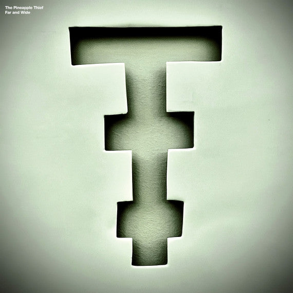 Album cover art for 'Far and Wide' by The Pineapple Thief, featuring a large, stylized, stepped letter 'T' in a dark green hue against a matching textured off-white background.