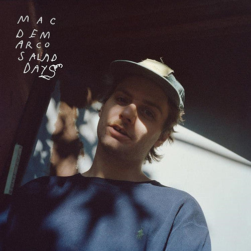 Album cover of Mac DeMarco's Salad Days LP featuring a photograph of Mac DeMarco wearing a cap, in a casual setting with trees and sky in the background.