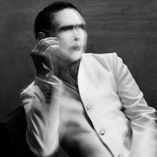 Black and white album cover featuring a person in a white suit, sitting and holding a cigarette.