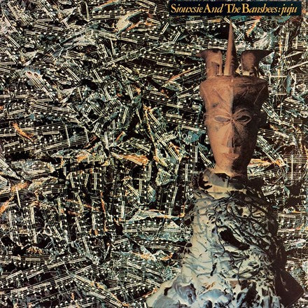 The image features the album cover of "Juju" by Siouxsie And The Banshees. It shows a blurred, artistic depiction of Siouxsie Sioux with abstract, dark-colored shapes in the background, giving a mystical or dreamlike quality to the image.