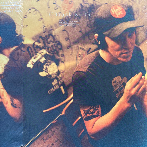 The image shows the back cover of the 'Either/Or' LP by Elliott Smith. It features a mirrored background with graffiti and the artist's reflection.