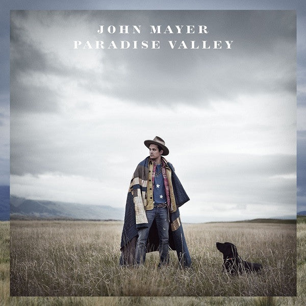 Cover art for John Mayer's album Paradise Valley featuring John Mayer standing in a field with a hat and jacket, with a dog by his side.