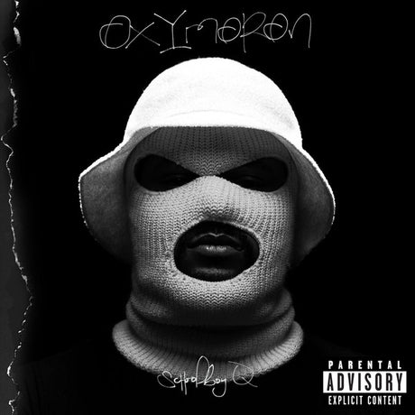 The image features the cover art for the album 'Oxymoron' by Schoolboy Q. The cover depicts a stylized photograph of the artist wearing a white bucket hat with the brim cut off, and a black and white mask covering the lower half of his face.