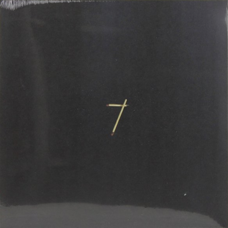 A black vinyl record with a gold-colored cross on the cover.