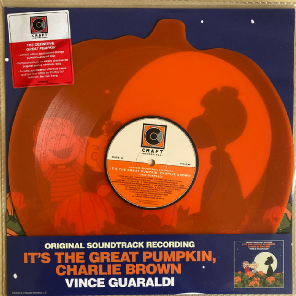 An orange, pumpkin-shaped vinyl record of Vince Guaraldi's soundtrack for 'It's The Great Pumpkin, Charlie Brown'. The cover features a silhouette of Charlie Brown and a pumpkin with a full moon in the background.