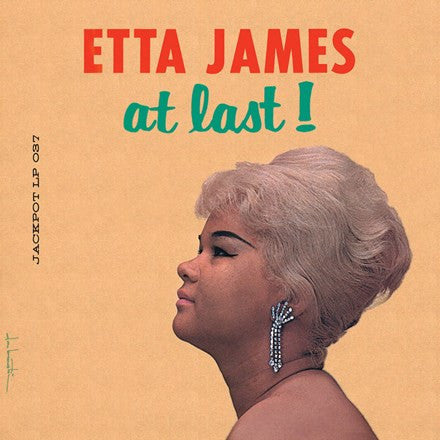Album cover of Etta James' 'At Last' featuring a photograph of Etta James with a side profile, wearing earrings and a light-colored top against a beige background.