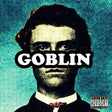 The image features the cover art for Tyler the Creator's album "Goblin." The cover depicts a stylized, portrait-style image of Tyler, with his prominent, expressive eyes and a serious expression, set against a vibrant blue background.