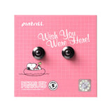 Earring set with Snoopy design on a pink grid background, featuring the brand 'Pintrill'.