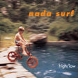 Album cover art for 'high/low' by nada surf, featuring a blurred vintage photograph of a boy riding a small red bicycle over the edge of a swimming pool, with orange and white text.