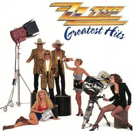 Album cover for ZZ Top's 'Greatest Hits' featuring the band members and two women posing with film production equipment on a white background, with the ZZ Top logo at the top.