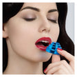 A close-up of a woman with closed eyes applying a small blue cylindrical lip product to her lips with her finger.