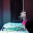 Album cover art for 'Dizzy Up The Girl' by The Goo Goo Dolls, featuring a woman lying on a bed in a dimly lit room with patterned wallpaper and dark curtains.