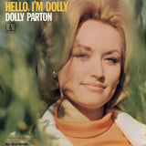 Album cover for Dolly Parton's 'Hello, I'm Dolly' featuring a close-up portrait of Dolly Parton with blonde hair, wearing an orange turtleneck and white jacket, set against a soft-focus green outdoor background. The text 'HELLO, I'M DOLLY' is in yellow, and 'DOLLY PARTON' is in white.