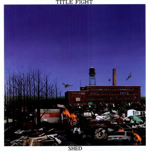 This image features the album cover for "Shed" by Title Fight, a debut full-length LP set in Kingston, PA. The cover depicts a desolate, post-apocalyptic scene with a large, old factory building at the center, surrounded by rubble and debris, including burnt-out cars and a fire hydrant.