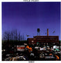 This image features the album cover for "Shed" by Title Fight, a debut full-length LP set in Kingston, PA. The cover depicts a desolate, post-apocalyptic scene with a large, old factory building at the center, surrounded by rubble and debris, including burnt-out cars and a fire hydrant.