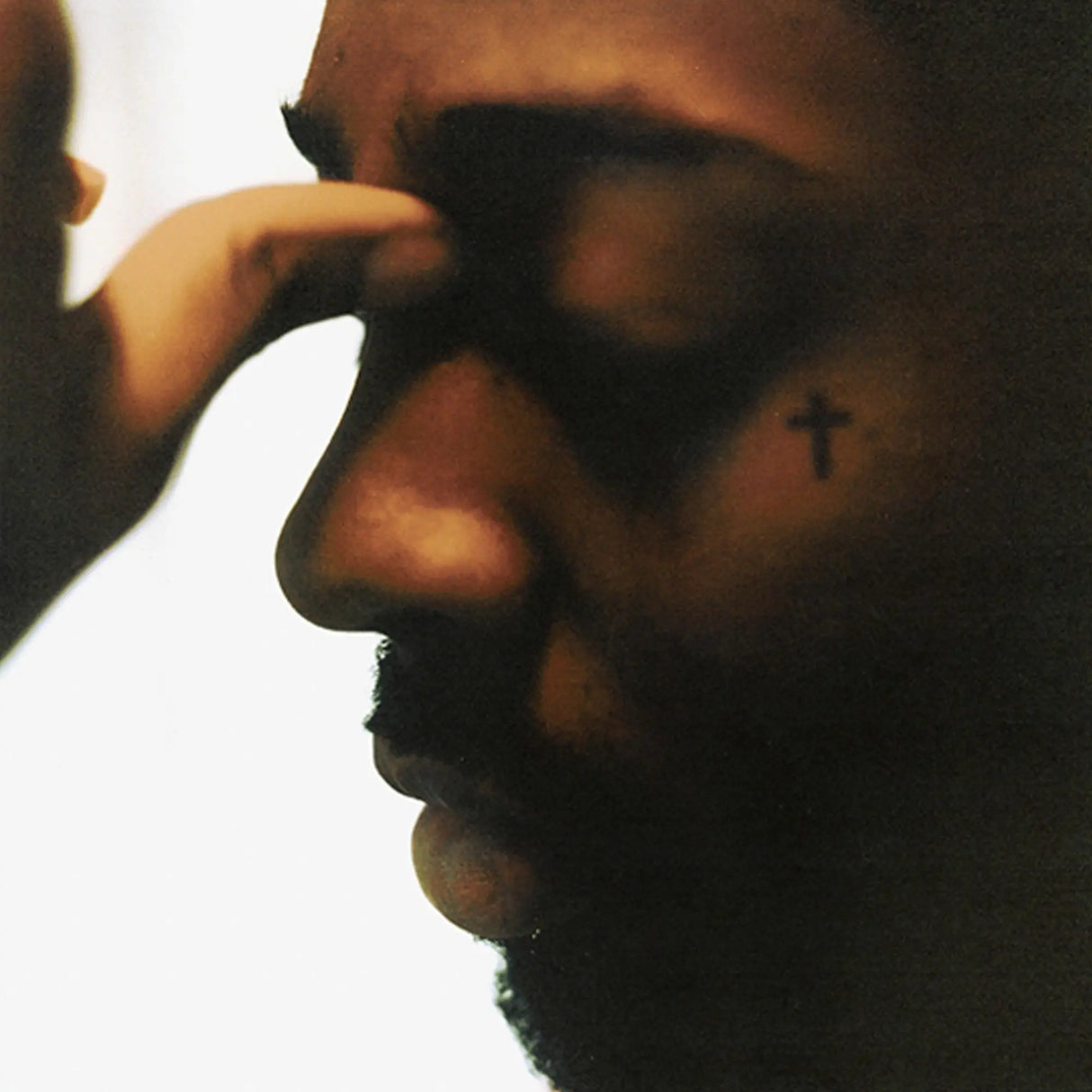 Close-up of a person with a tattoo on their face, with a blurred background.