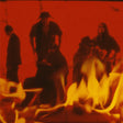 Group of people around a fire with a red filter