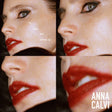 Close-up of a person's face with red lipstick, featuring text and the brand 'Anna Calvi'.
